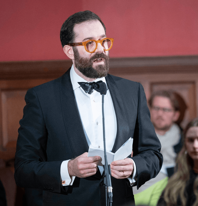Image of Jonathan Sacerdoti speaking at a microphone
